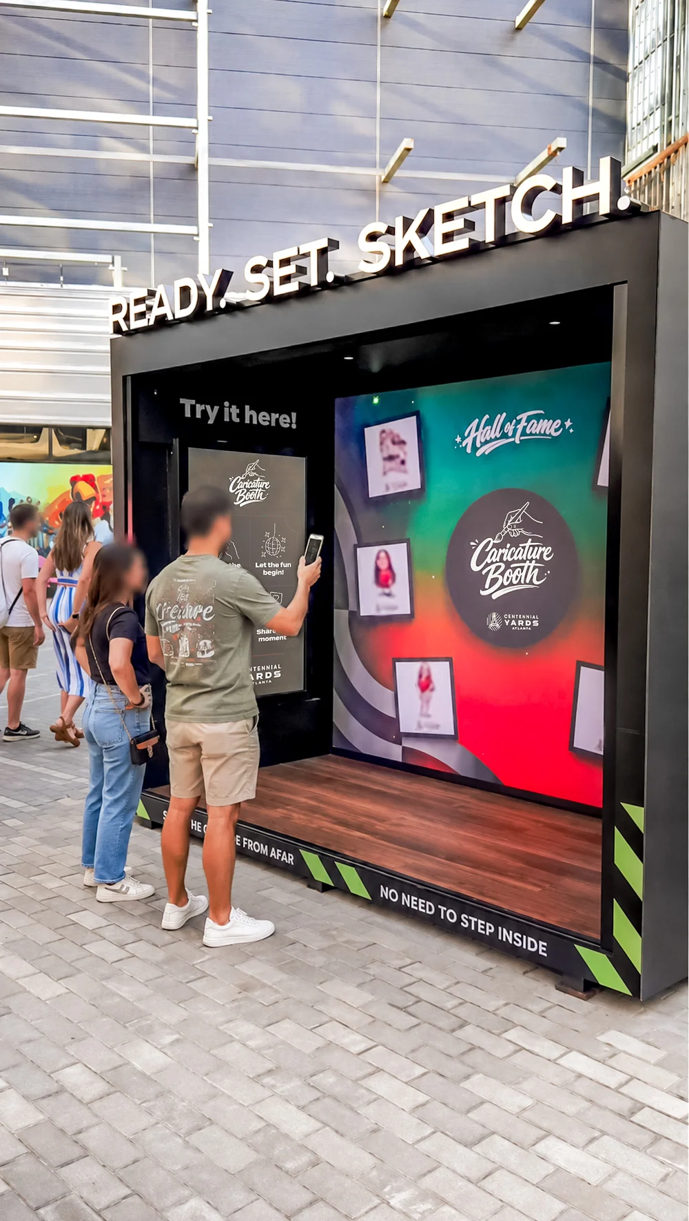 Visitors using a Caricature Booth activation